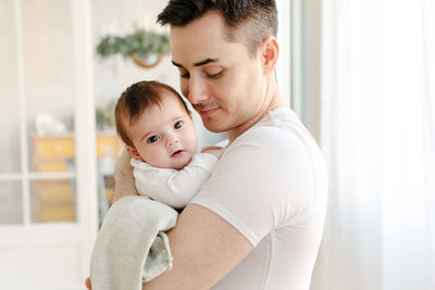 Happy father standing with baby in arms