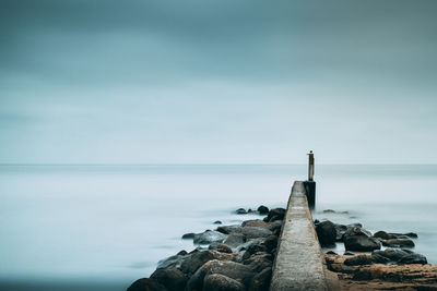 Close-up of groyne in sea against sky