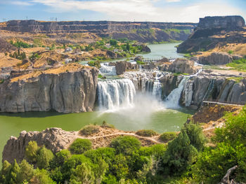 Scenic view of waterfall against sky