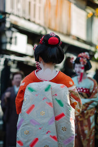 Rear view of woman wearing kimono at road