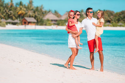 Full length of family standing on beach