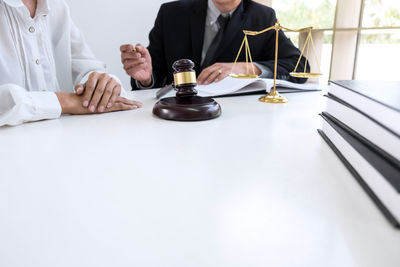 Midsection of lawyers working at desk in courtroom