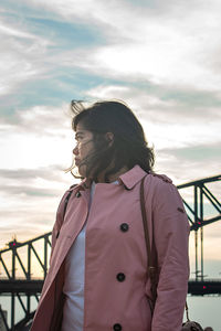 Woman standing behind a bridge against sky