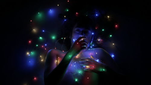 Digital composite image of woman against illuminated lights