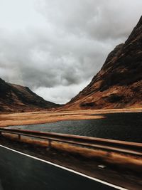 Road by mountain against sky