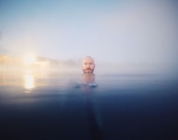 Man swimming in beach at sunset