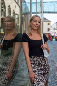 Portrait of young woman standing in city