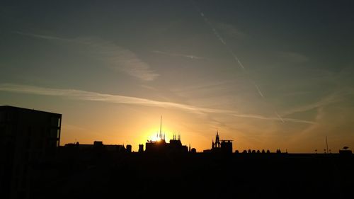 Silhouette buildings against sky during sunset