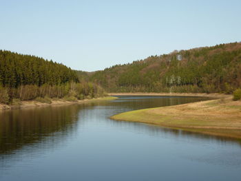 Scenic view of lake in forest against clear sky