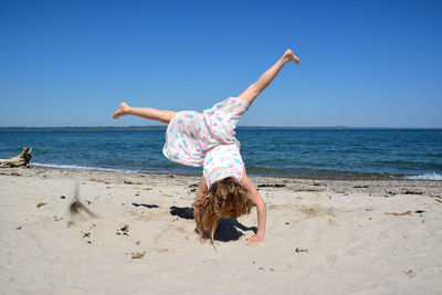 Girl doing a cartwheel on beach