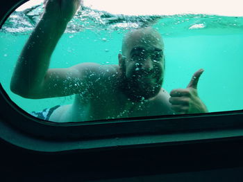 Portrait of shirtless man swimming in pool