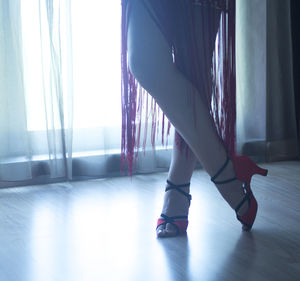 Low section of woman standing on floor at home