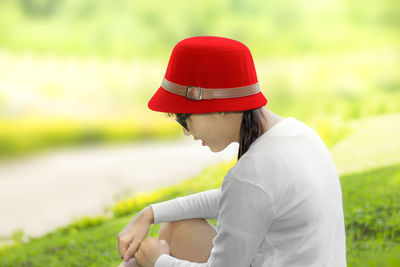 Side view of woman wearing hat on field