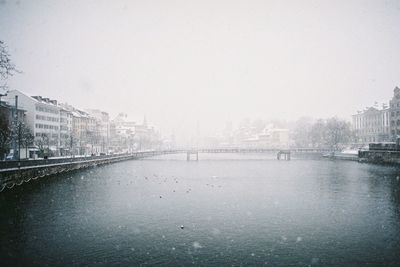 River in city against clear sky during winter