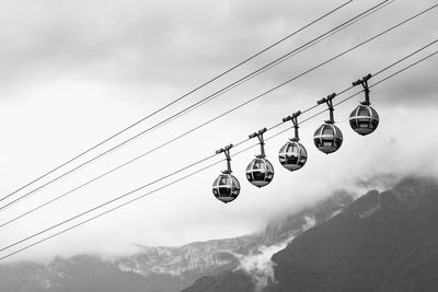 Low angle view of overhead cable car against sky