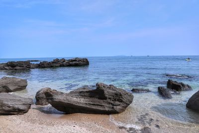 Scenic view of rocks on beach against sky