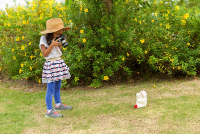 Rear view of woman holding umbrella against plants