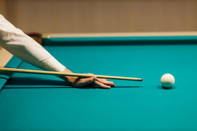 Cropped hand playing pool table