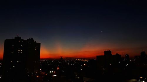 Silhouette buildings against sky during sunset