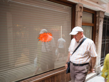 Man working with umbrella walking on building