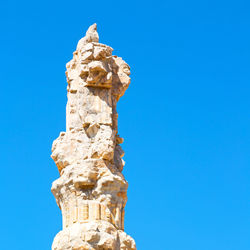 Low angle view of statue against blue sky