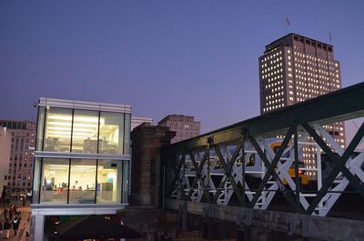 Low angle view of illuminated skyscraper against clear sky