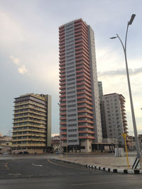 Street by buildings against sky