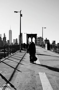 Rear view of people walking on street against buildings