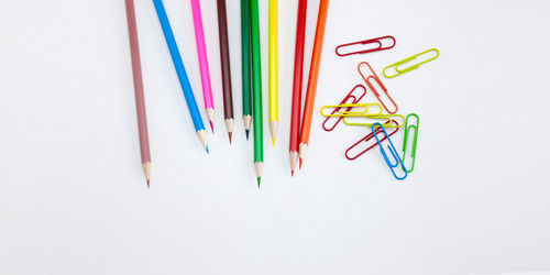 High angle view of multi colored pencils on white background