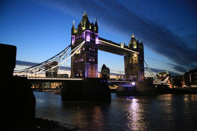 View of bridge over river at night