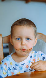 Little cute boy eating bread with chocolate butter