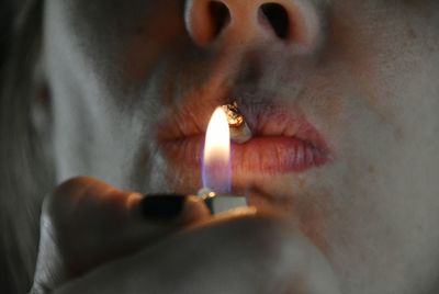 Close-up of lit candle in darkroom