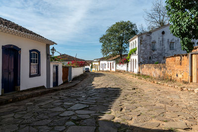 Footpath amidst buildings against sky