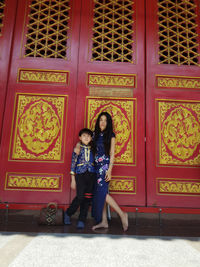 Full length of woman standing against wall
