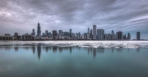 Distant view of city against cloudy sky