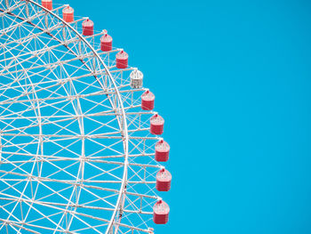 Low angle view of ferris wheel against blue sky