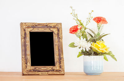 Close-up of vase on table against white background
