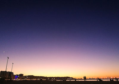 Silhouette buildings against clear sky at night