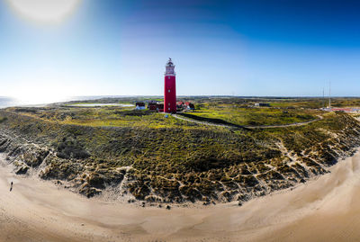 Lighthouse on beach against sky