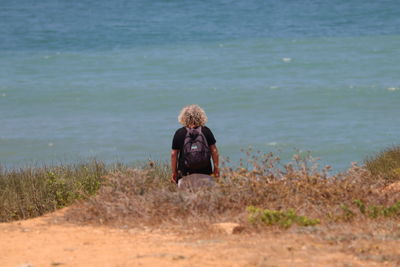 Rear view of man standing against sea
