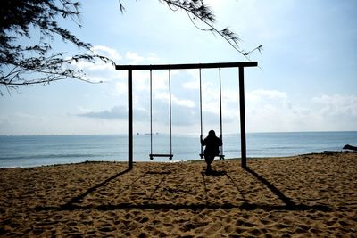 Rear view of man on beach against sky