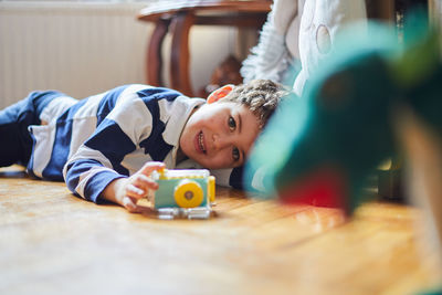 A boy takes photos of his toys with his camera