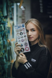 Portrait of a beautiful young woman holding camera