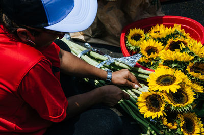 Midsection of man holding yellow flowers