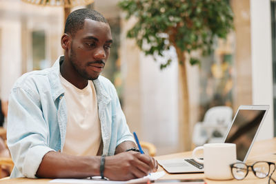 Young man using laptop at office