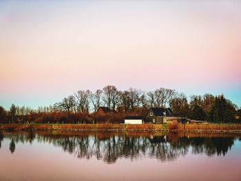 Reflection of trees in lake against sky during sunset