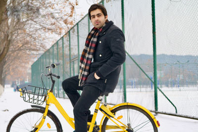 Side view portrait of man riding bicycle during winter