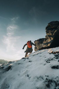 Rear view of man skiing on snow covered landscape