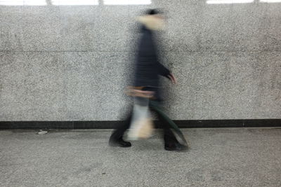 Blurred motion of man walking on sidewalk