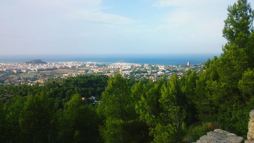 High angle view of townscape by sea against sky